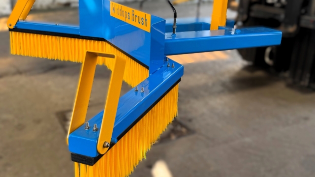 Side view of a yellow and blue forklift sweeper