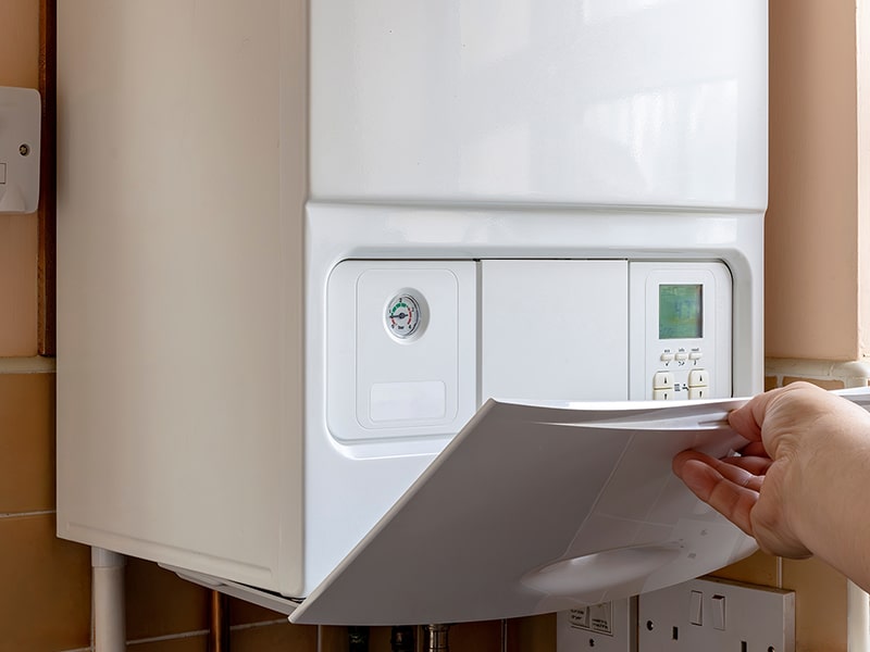 household boiler with someone opening the flap at the bottom